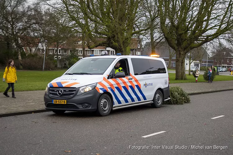 Agenten helpen kinderen met inzamelen kerstbomen