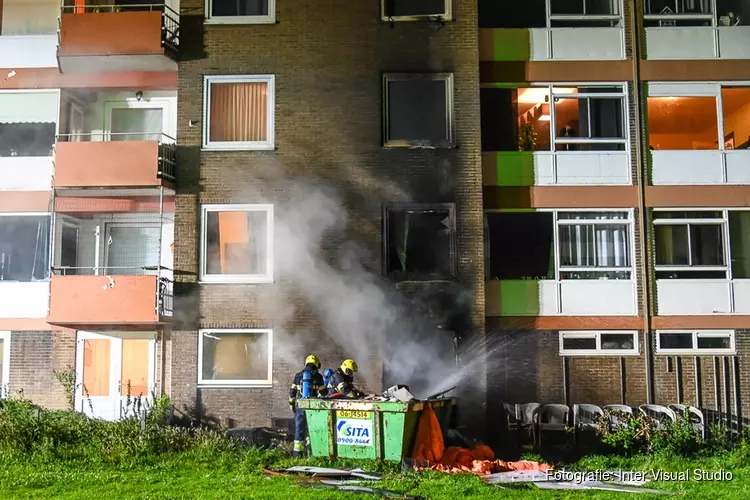 Containerbrand slaat over op flat: woningen ontruimd, veel schade