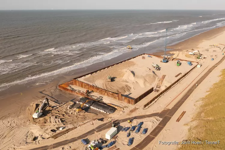 Eerste mantelbuis voor windenergie van zee onder duinen door getrokken bij Heemskerk