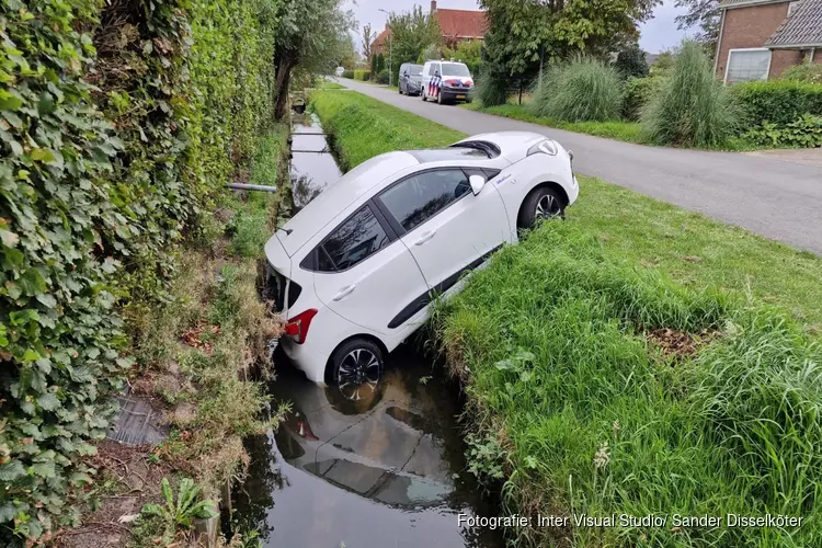 Handrem vergeten, auto rolt sloot in